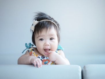 Closeup cute baby girl in funny motion with copy space