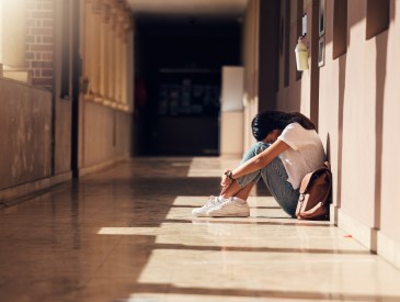 Anxious teen girl in school hallway
