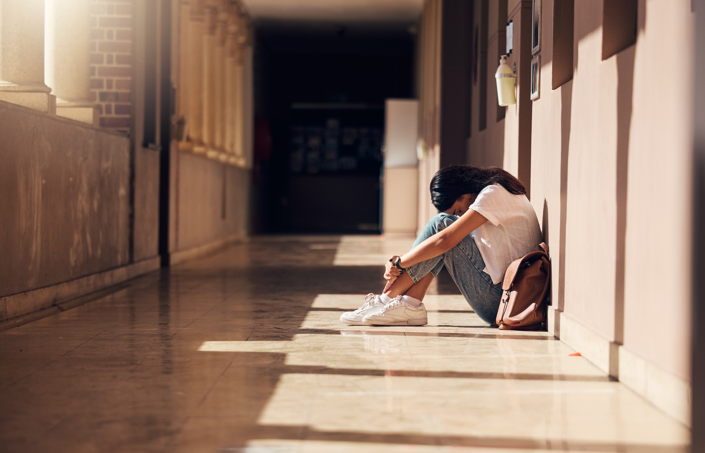 Anxious teen girl in school hallway