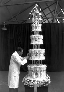 14th November 1947:  Mr Schur, chief confectioner at McVitie and Price, putting the final touches to the wedding cake of Princess Elizabeth and The Prince Philip, Duke of Edinburgh. The cake has four tiers and is nine feet high.  (Photo by J. A. Hampton/Topical Press Agency/Getty Images)