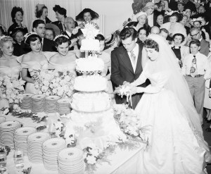 (Original Caption) 5/9/1950-Beverly Hills, CA: Conrad Nicholson Hilton, Jr., heir to a hotel fortune, and his bride, actress Elizabeth Taylor, cut their huge wedding cake at a reception following the marriage. They will honeymoon in Europe for three months. BPa 2 #1976