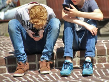 teens looking at phone