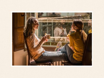Mom and daughter talk by the window.