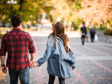 Teen couple walking in a park, holding hands